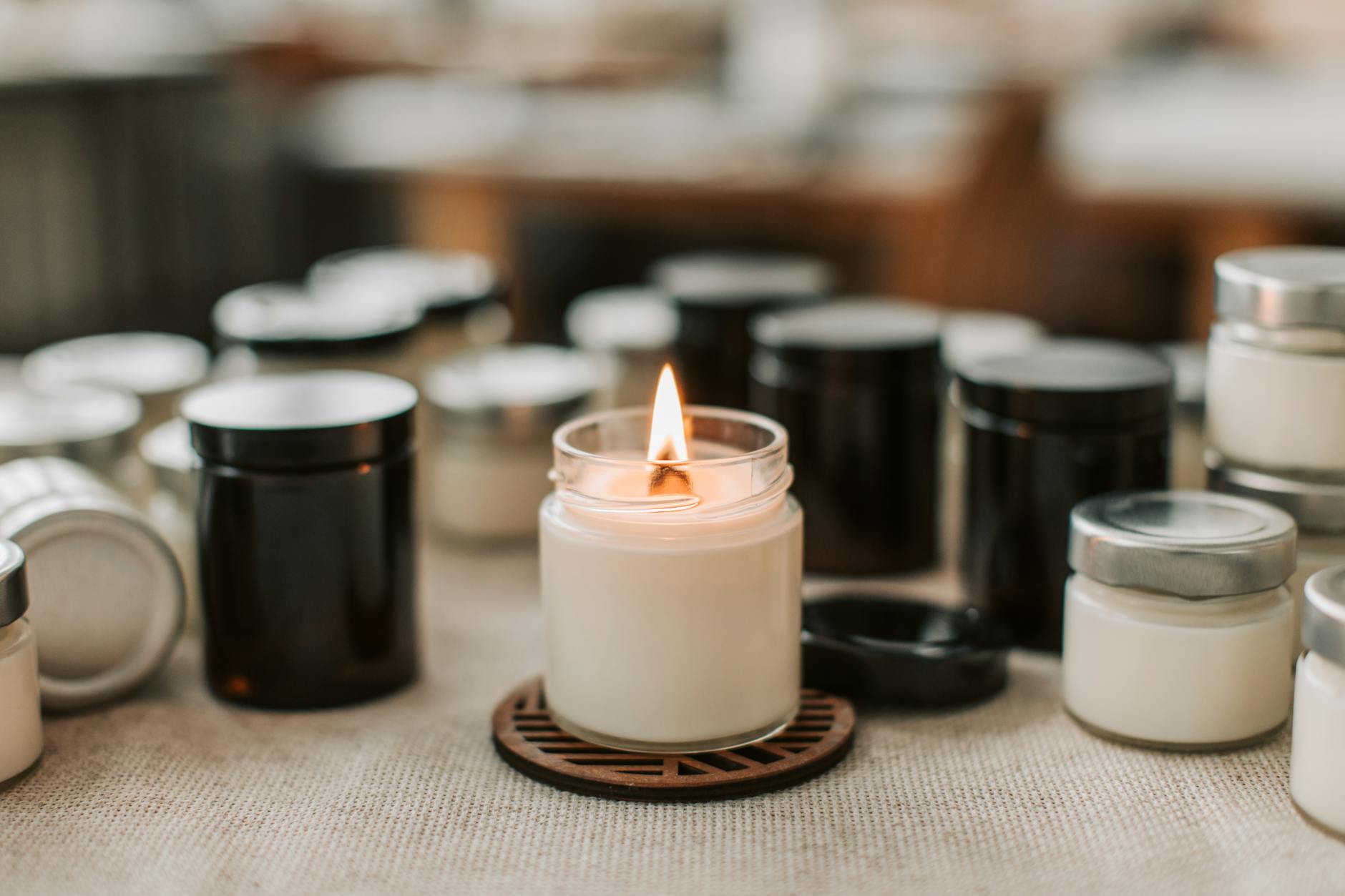 close up of a burning candle among black and white candles standing on the table